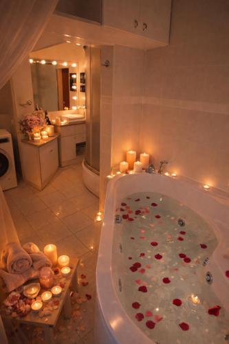 a bathroom with a bath tub filled with candles at Cozy Garden Villa in Ventspils