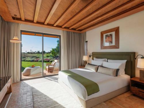 a bedroom with a large bed and a large window at Fairmont Royal Palm Marrakech in Marrakesh