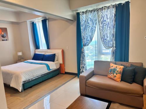 a bedroom with a bed and a couch at C1-7G Executive Studio with pool , 8boulevard Mactan Newtown in Lapu Lapu City
