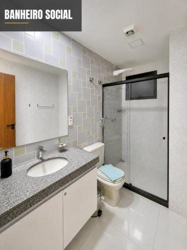 a bathroom with a toilet and a sink and a shower at Flat Pasárgada 404 in Vila Velha