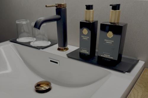 a bathroom sink with two bottles of soap and a faucet at Nordic Retreat Quiet Oasis in Oslo in Oslo