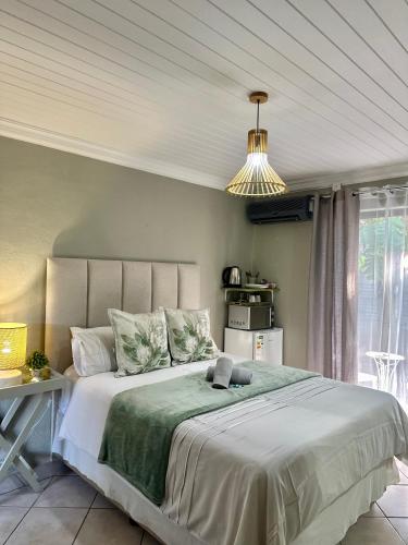 a bedroom with a large bed and a pendant light at Guesthouse 52 in Groblersdal