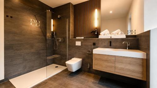 ein Badezimmer mit Waschbecken, Toilette und Dusche in der Unterkunft Pawlow History Hotel in Wolkenstein
