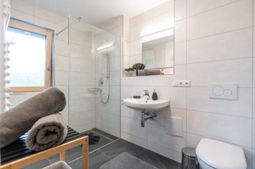 a white bathroom with a sink and a toilet at FeWo Iller im Allgäu in Sonthofen