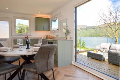 a kitchen and living room with a table and chairs at Kilbride Lodge in Carrick