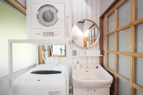 a bathroom with a sink and a washing machine at Villa Vino in Fuefuki