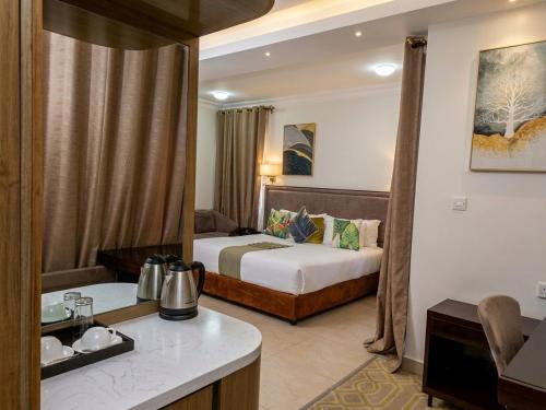 a hotel room with two beds and a kitchen at Cycad Palm Hotel in Gaborone