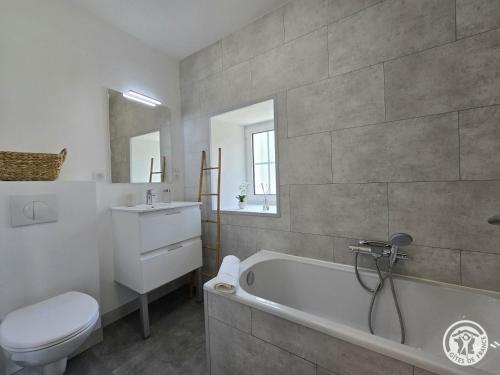 a bathroom with a tub and a toilet and a sink at Chadalou in Savignac-les-Églises