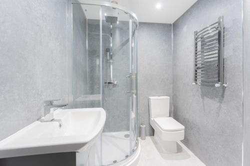 a bathroom with a shower and a sink and a toilet at 4 Bedroom modern apartment in Birkenhead