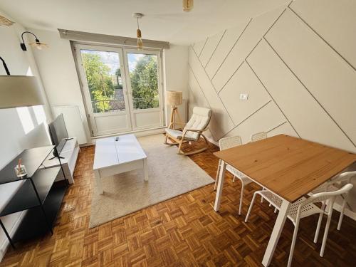 a living room with a wooden table and a wooden floor at Le T3 Malpeaux – Arras Centre in Arras