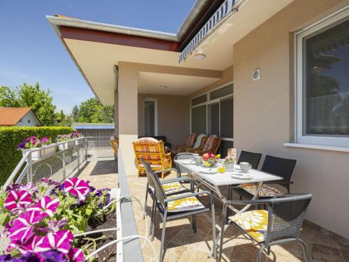 a patio with a table and chairs and flowers at Apartment Beige by Interhome in Balatonszemes