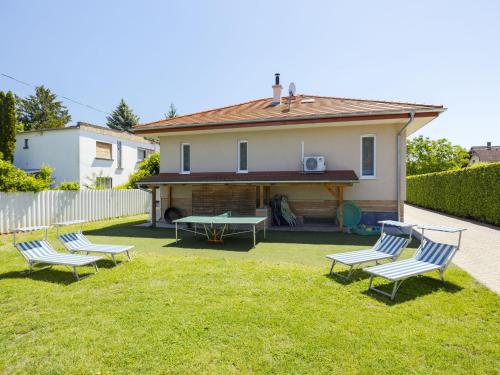 a group of chairs sitting in the yard of a house at Apartment Beige by Interhome in Balatonszemes