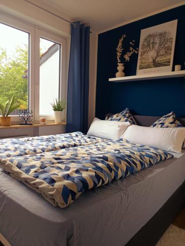 a bedroom with a large bed with blue walls at Ferienwohnung Luitpold 1 in Memmingen