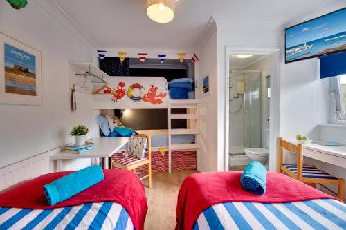 two beds in a room with a bunk bed at The Hides in Seahouses