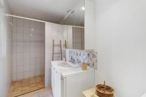 a white bathroom with a sink and a mirror at Maison Des Hôtes - Dordogne in Saint-Crépin-dʼAuberoche
