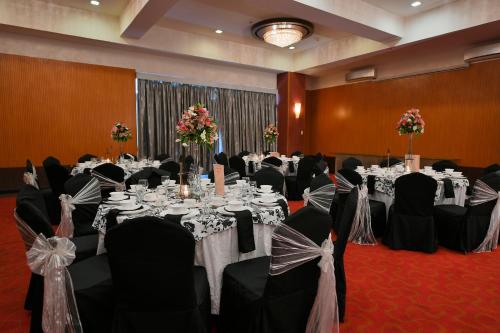 a banquet hall with white tables and black chairs at Paseo Premiere Hotel in Santa Rosa