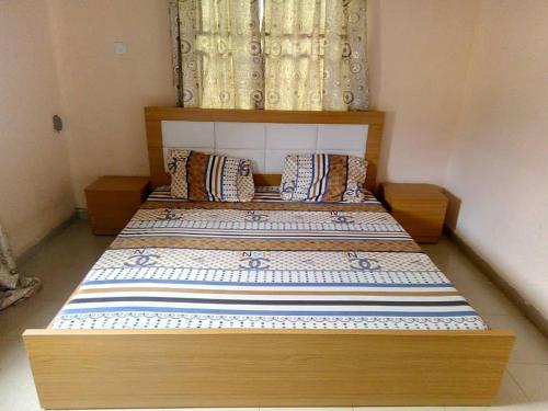 a bed with a wooden frame in a room at Edo Home in Benin City