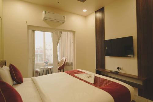 a hotel room with a bed and a television at Hotel Ayodhya Inn in Lokāpur