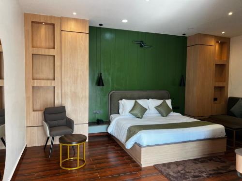 a bedroom with a bed with a green wall at Nandan Inn in Dibrugarh
