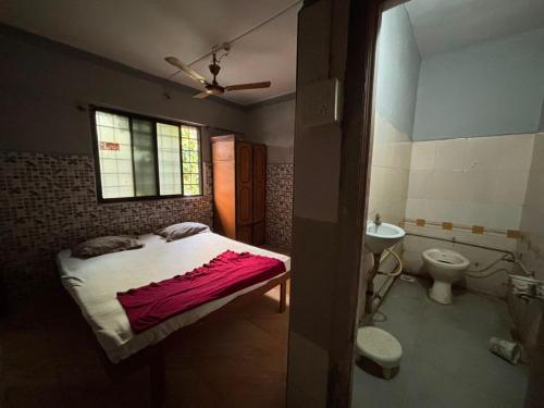 a bedroom with a bed and a sink and a toilet at Shree Hariraj Guest House in Vapi