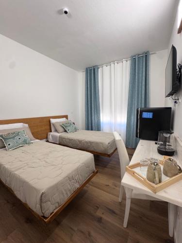 a room with two beds and a table with a computer at aliseo in Olbia