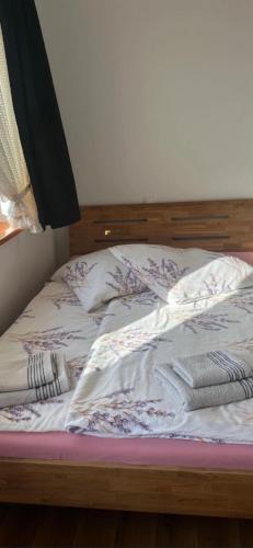 an unmade bed with two blankets and pillows on it at Agroturystyka Matłak in Matłak
