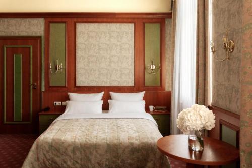 a bedroom with a bed and a table and a window at Hotel Fürstenhof Bad Bertrich in Bad Bertrich