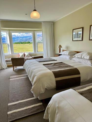 a bedroom with two beds and a large window at Estancia Cristina Lodge - El Calafate in Estancia Cristina