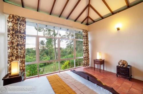 a bedroom with a large window and a bed at The Montfort - Kandy in Kandy
