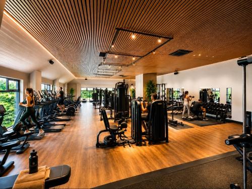 a gym with treadmills and people exercising in machines at The Wiltshire Hotel, Golf and Leisure Resort in Swindon