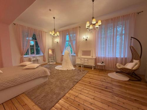a bedroom with a bed and a wedding dress in it at Viesnīca Meirānu Muiža in Meirāni