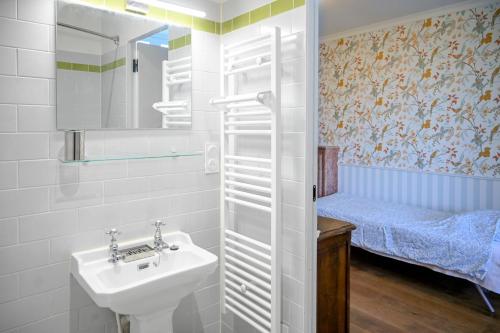 a small bathroom with a sink and a bed at Château de Saint Clair in Saint-Clair-sur-lʼElle