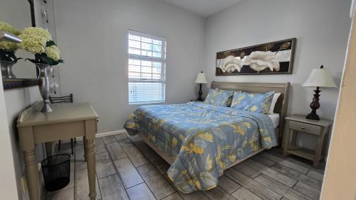 a bedroom with a bed and a table and a desk at La Palma villas 6 in Mossel Bay