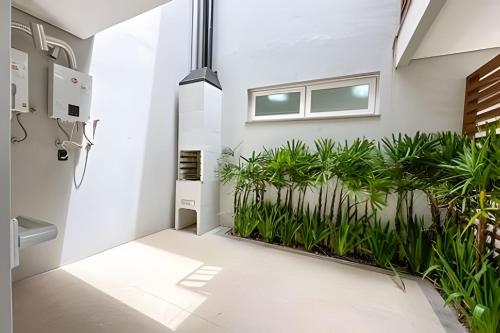 a room with plants on the wall at Condomínio Brises Downtown Garopaba in Garopaba