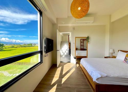 a bedroom with a bed and a large window at 根本家民宿 in Dayi