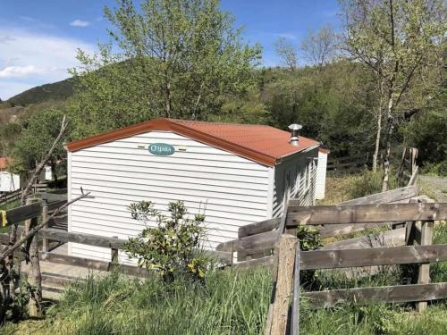 a white building with a red roof next to a fence at Camping 3 étoiles - Piscine - ccbgccf in Rennes-les-Bains