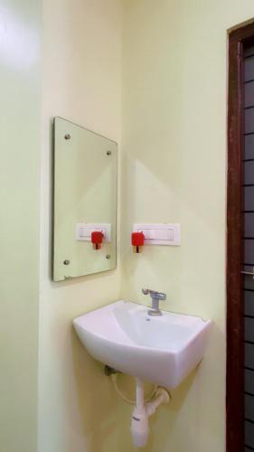 a white sink in a bathroom with a mirror at Khushi Homestay Hampi in New Hampi