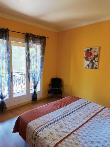a bedroom with a bed and a window at Mas de la Croix - Chambres d'hôtes in Sernhac