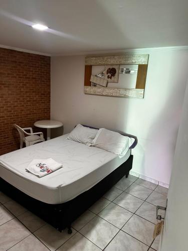 a bedroom with a bed and a mirror on the wall at Pousada Saturnino in Hortolândia