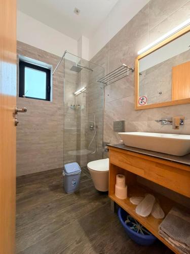 a bathroom with a sink and a toilet and a mirror at Hotel Sole in Sarandë