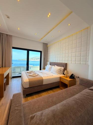 a large bedroom with a bed and a couch at Hotel Sole in Sarandë