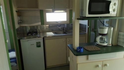 a small kitchen with a mixer and a microwave at Camping 3 étoiles - Piscine - ccbfihb in Casaglione