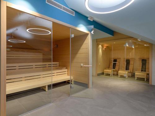 a room with a row of benches in a room at ibis Styles Bad Reichenhall in Bad Reichenhall