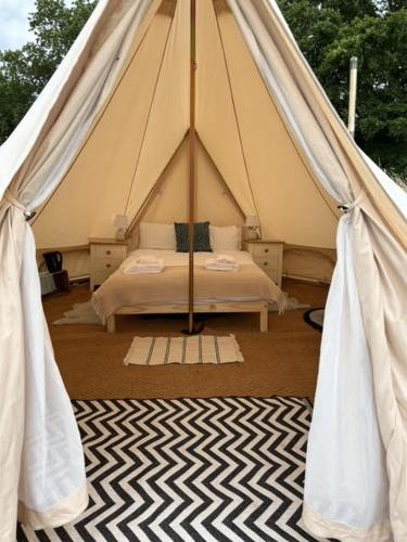 a tent with a bed in a room at Gresham Hall Glamping in Aylmerton