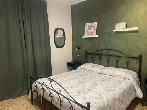 a bedroom with a bed and a green wall at BB Diesis in Ferrazzano