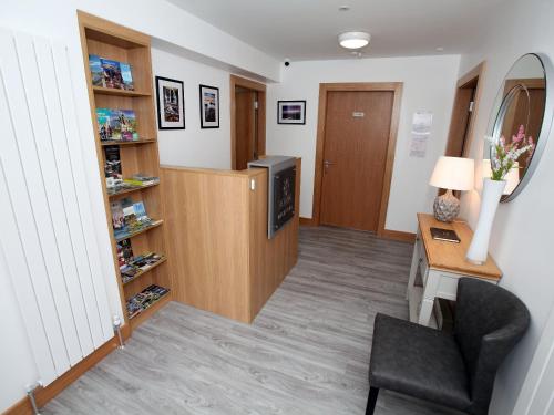 a room with a desk and a chair and a television at All Seasons B&B in Portrush