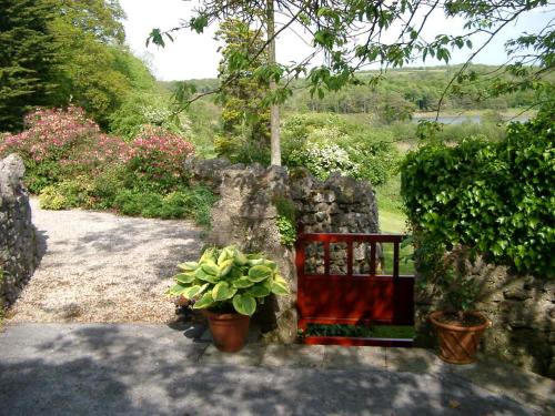 a garden with potted plants and a stone wall at challan hall in Silverdale