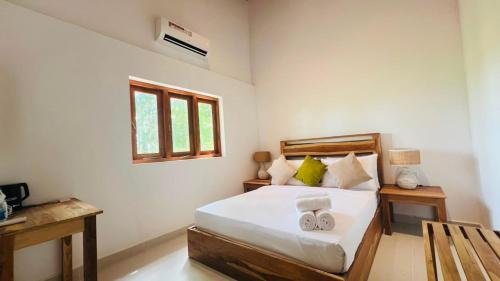 a bedroom with a bed with two towels on it at Safari Lodge Tempstay in Nochchiyagama