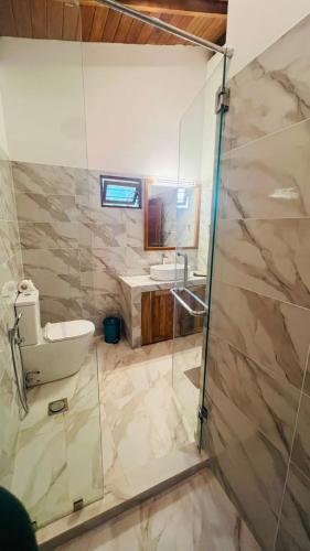 a bathroom with two sinks and a glass shower at Safari Lodge Tempstay in Nochchiyagama
