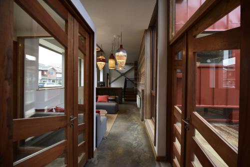 a hallway with wooden doors and a living room at Hotel Vendaval in Puerto Natales
